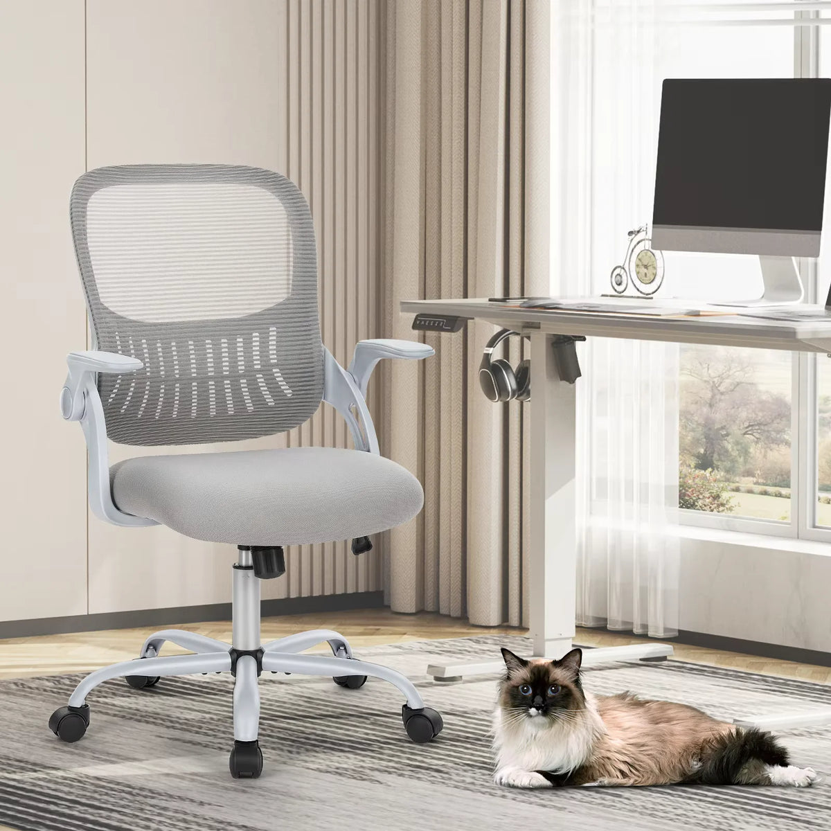 Chaise Ergonomique Essentiel — Gris — devant un bureau assis-debout, lumière du jour